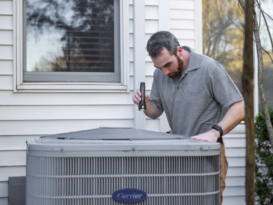 Technician inspecting a residential HVAC unit